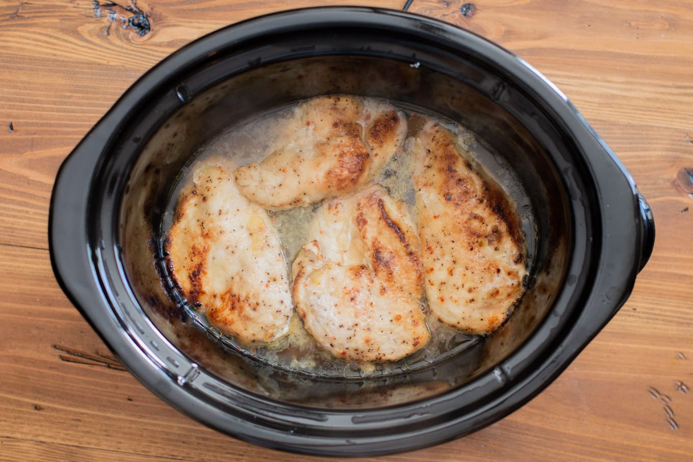 browned chicken breasts in a slow cooker.
