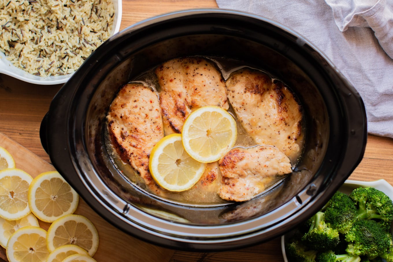 Finished cooking lemon chicken in a slow cooker with broccoli and rice on the side.