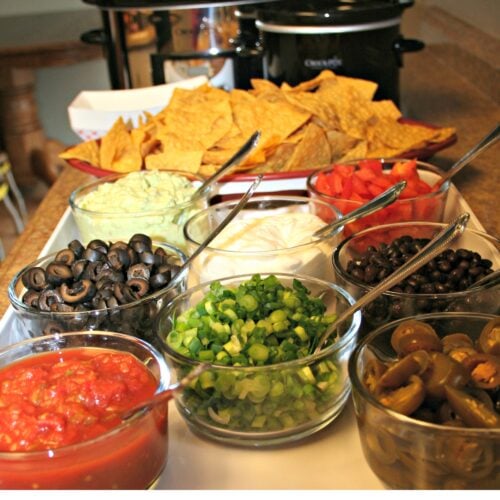 Nacho bar toppings with 2 crockpots in background