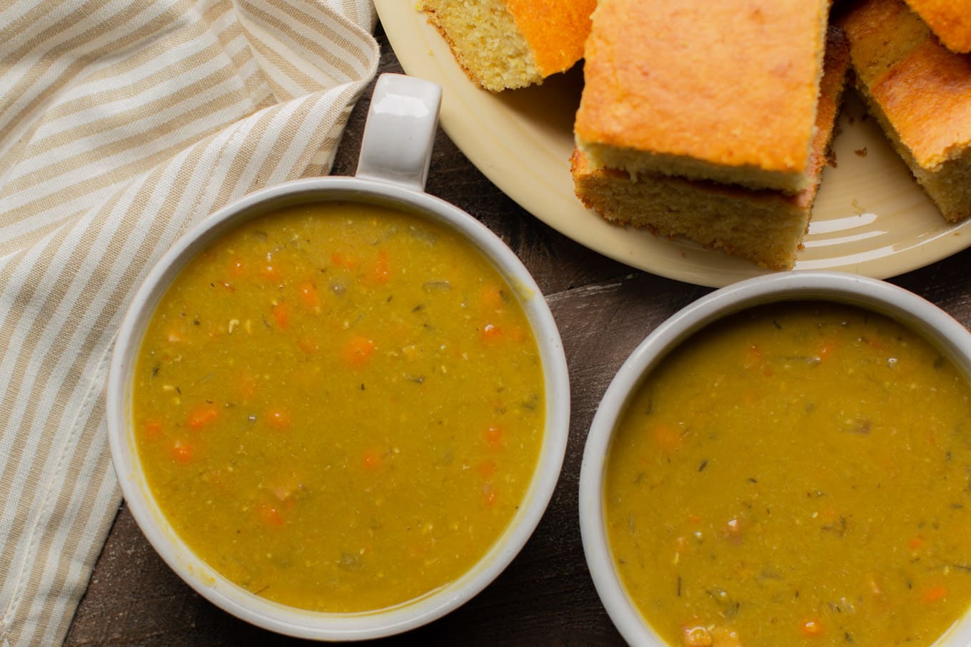 2 bowls of split pea with cornrbead on the side.