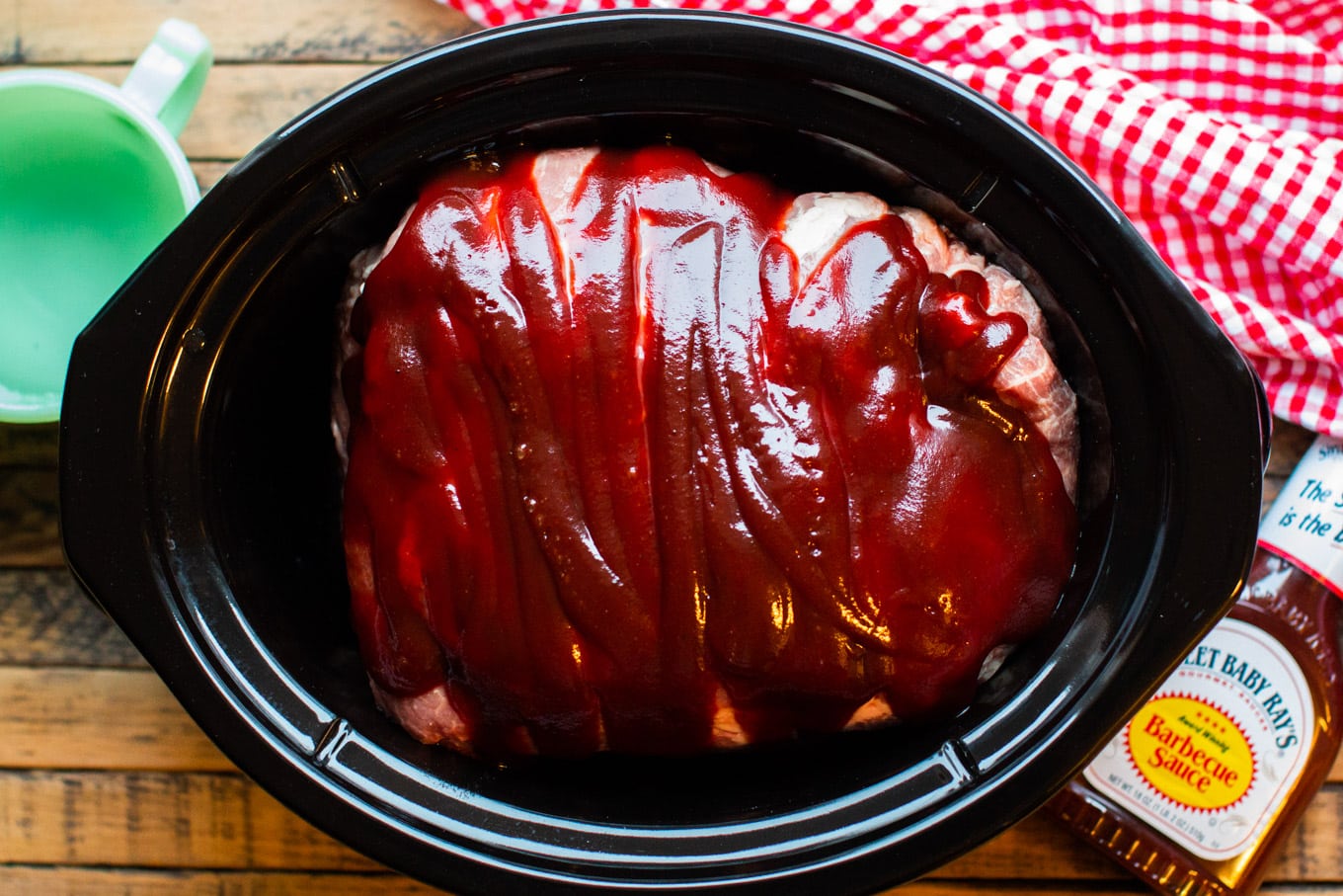 raw pork in slow cooker with water and barbecue sauce