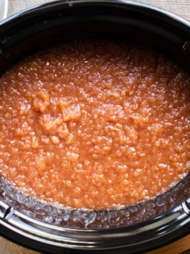 Cooked cinnamon applesauce in a slow cooker.