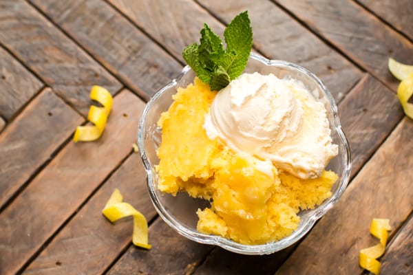 lemon spoon cake in glass bowl with ice cream on top.