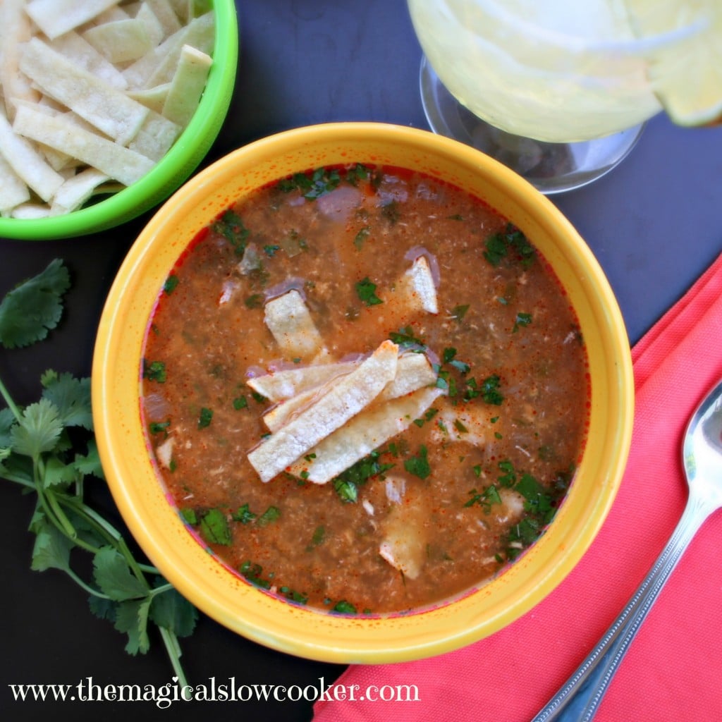 Chicken tortilla soup in a bowl with chopped cilantro and tortilla strips on top
