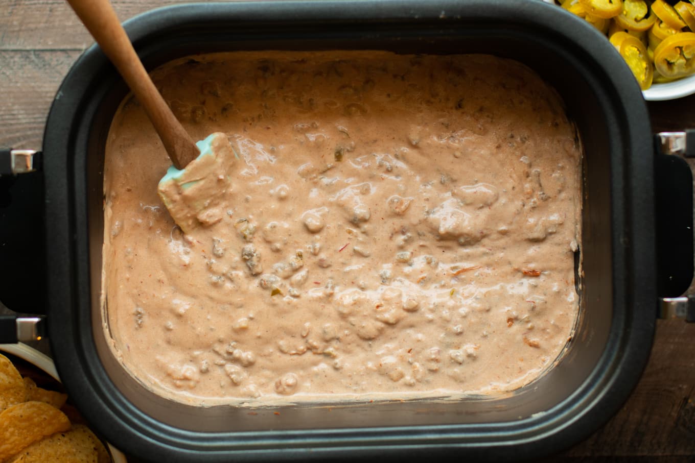 Cooked taco dip with spatula in it.