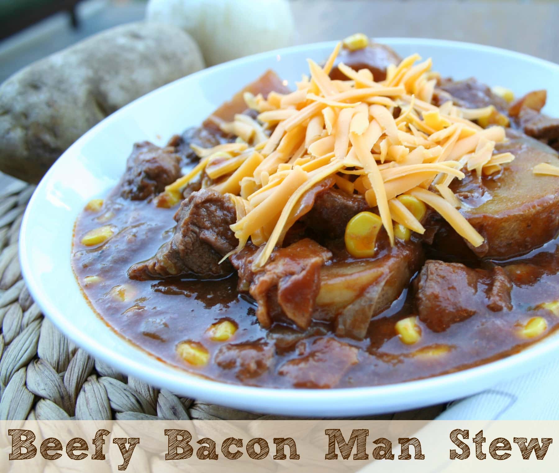 Beefy bacon man stew with shredded cheese on top in white bowl