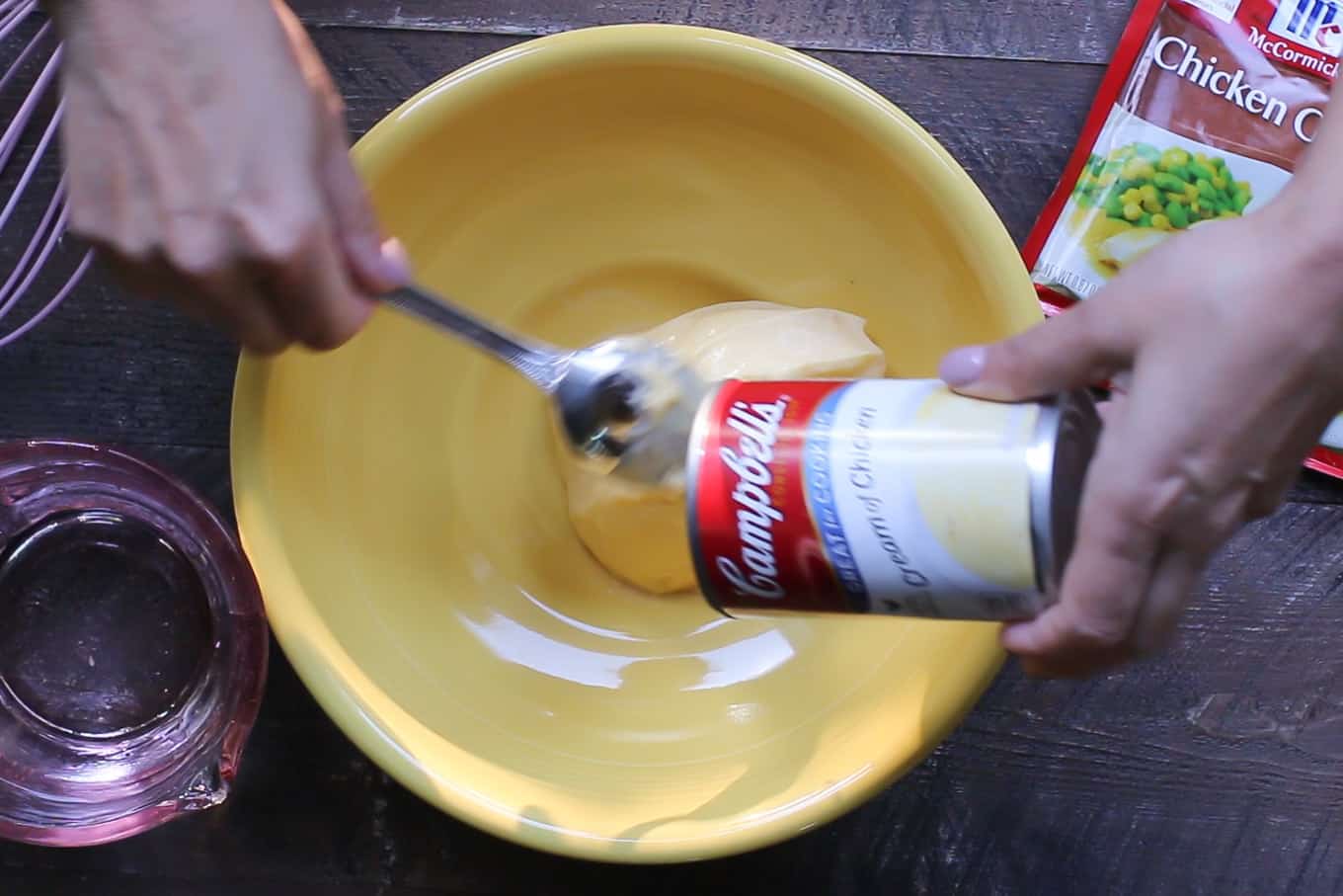 Cream of chicken soup being dumped out into a yellow bowl