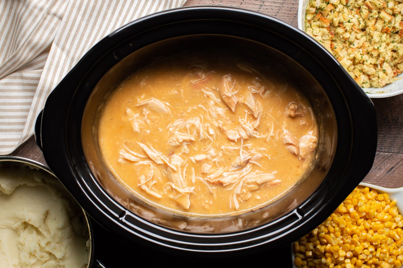 shredded chicken and gravy with corn, mashed potatoes and stuffing on the side.