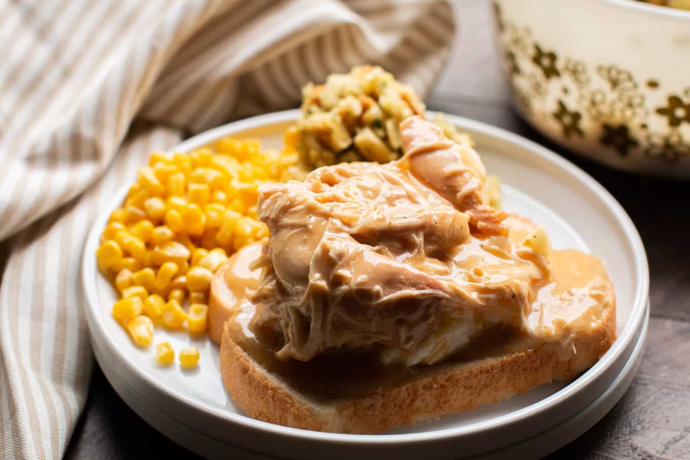 Close up of bread, mashed potatoes, chicken and gravy.