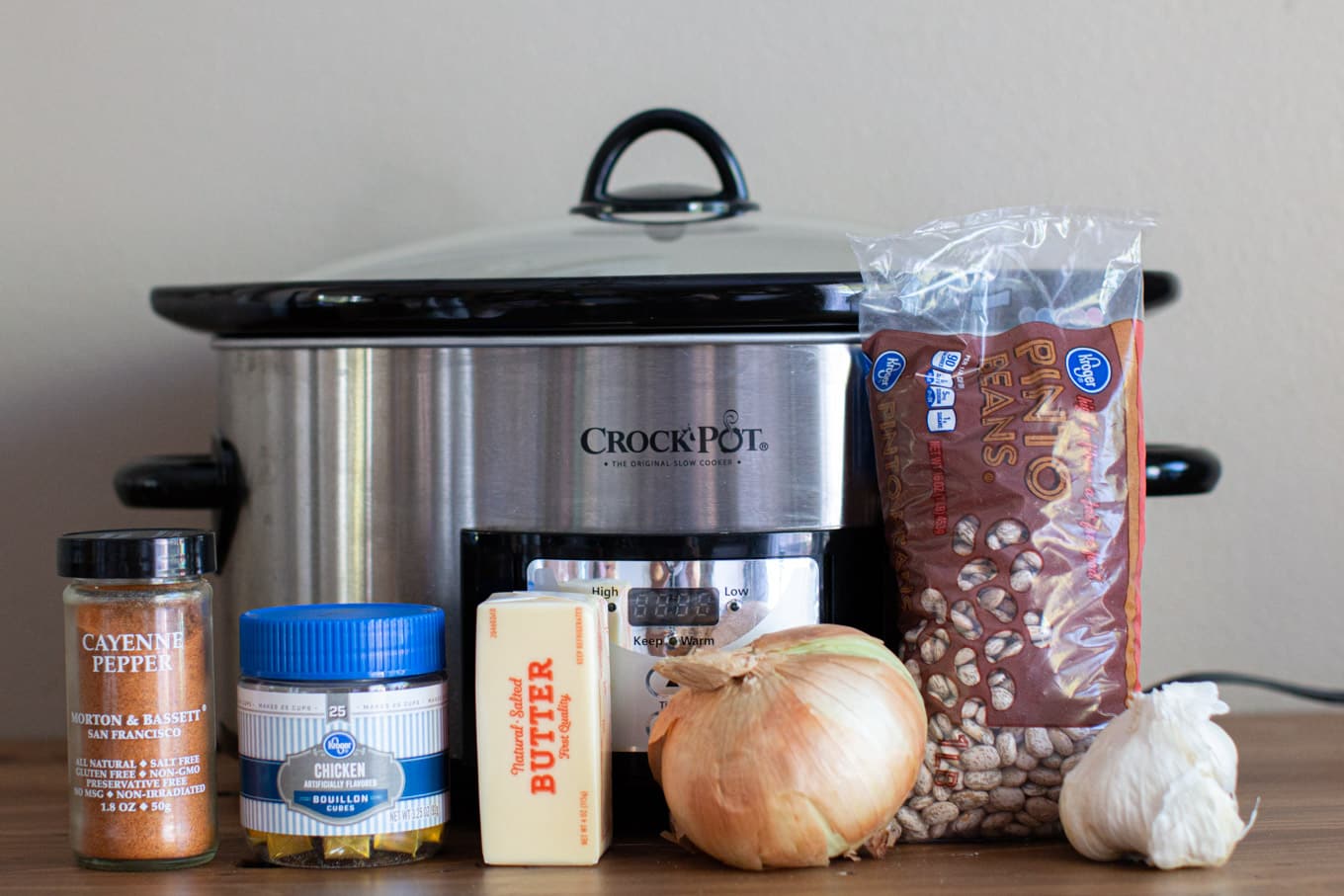 slow cooker with pinto beans, chicken bouillon, yellow onion, garlic and cayenne pepper.