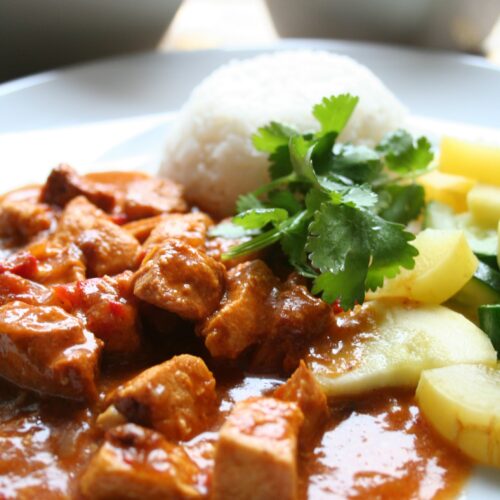 Chicken curry on plate with rice and zucchini