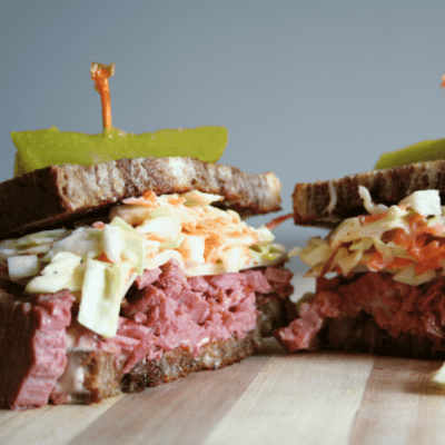 Reuben Sandwich cut in half on cutting board