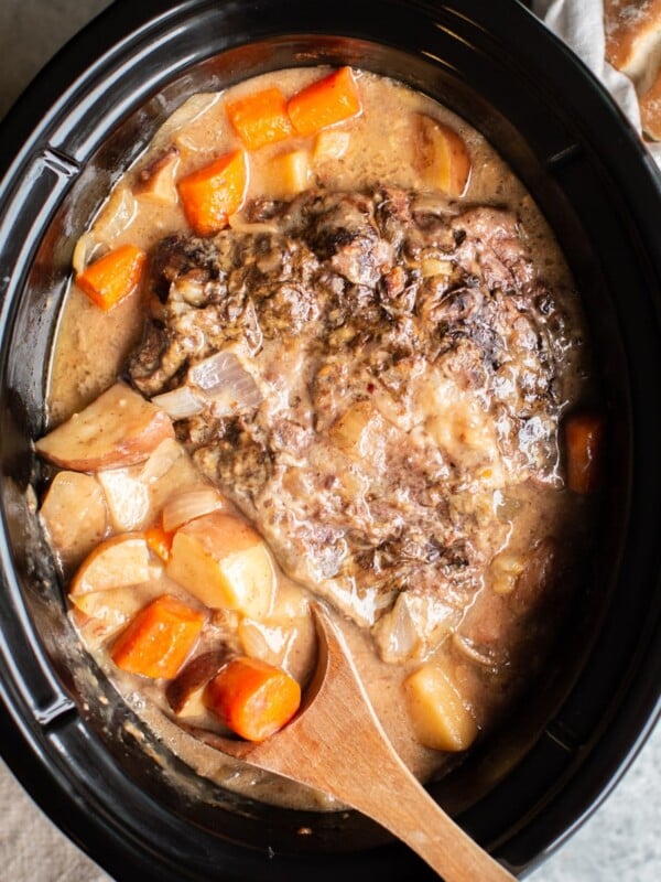 cooked pot roast with cooked vegetables around it.