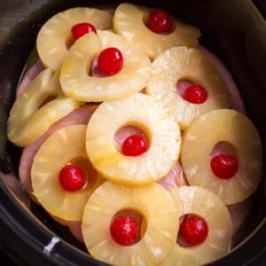 ham steaks in slow cooker with pineapple rings and maraschino cherries on top