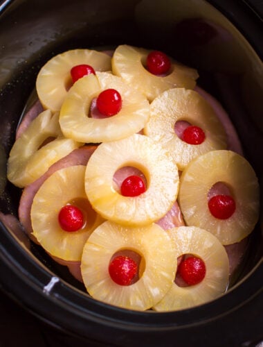 ham steaks in slow cooker with pineapple rings and maraschino cherries on top