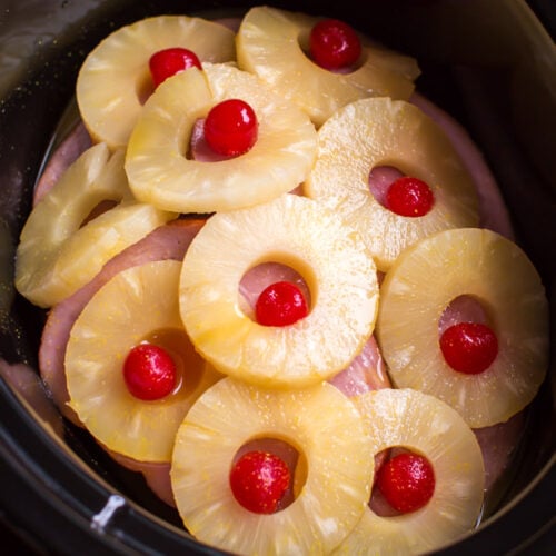 ham steaks in slow cooker with pineapple rings and maraschino cherries on top