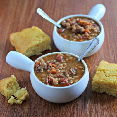 bean and bacon soup in bowls with cornbread on side