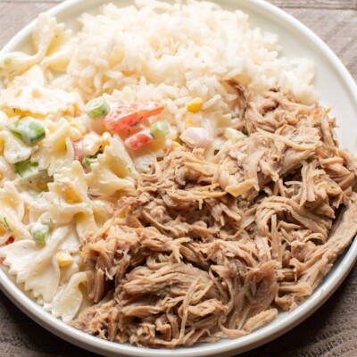 shredded pork, pasta salad and white rice on white plate.