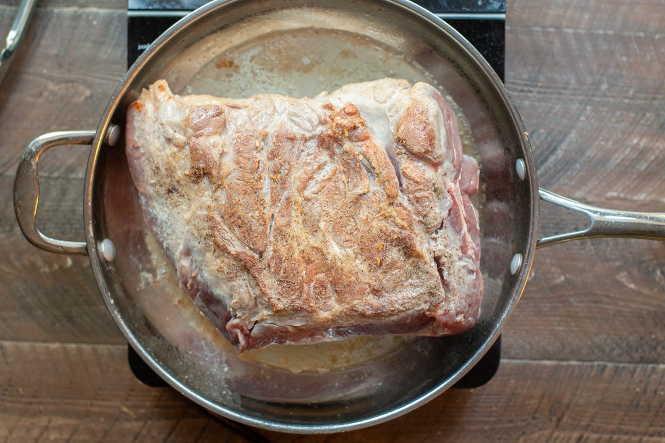 pork shoulder in a pan being browned.