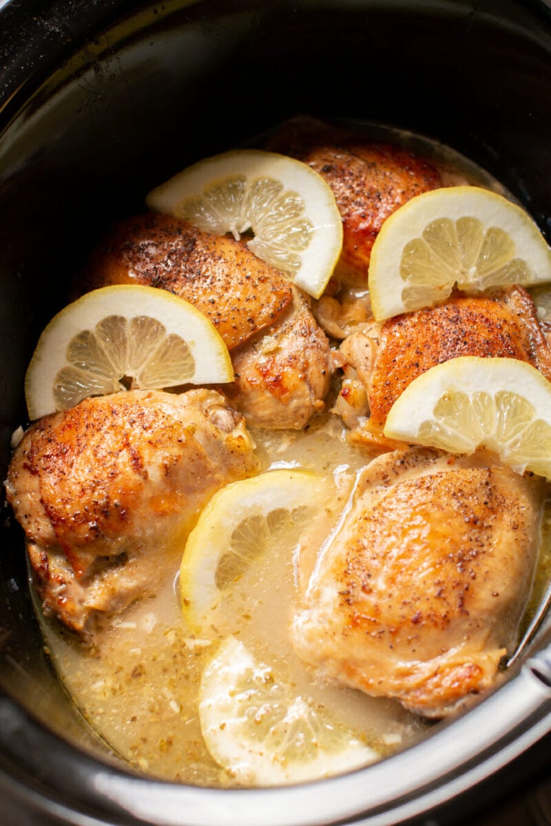 close up lemon pepper chicken thighs in crockpot