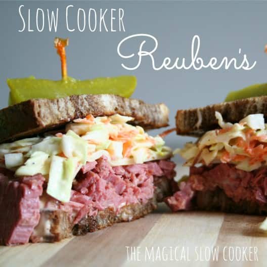 Reuben Sandwich on cutting board with pickles on top