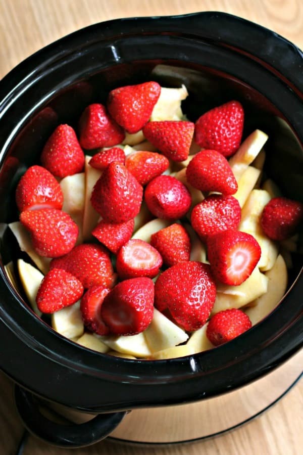 sliced apples and strawberries in round slow cooker
