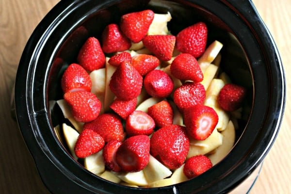 close up of strawberries and sliced apples in slow cooker