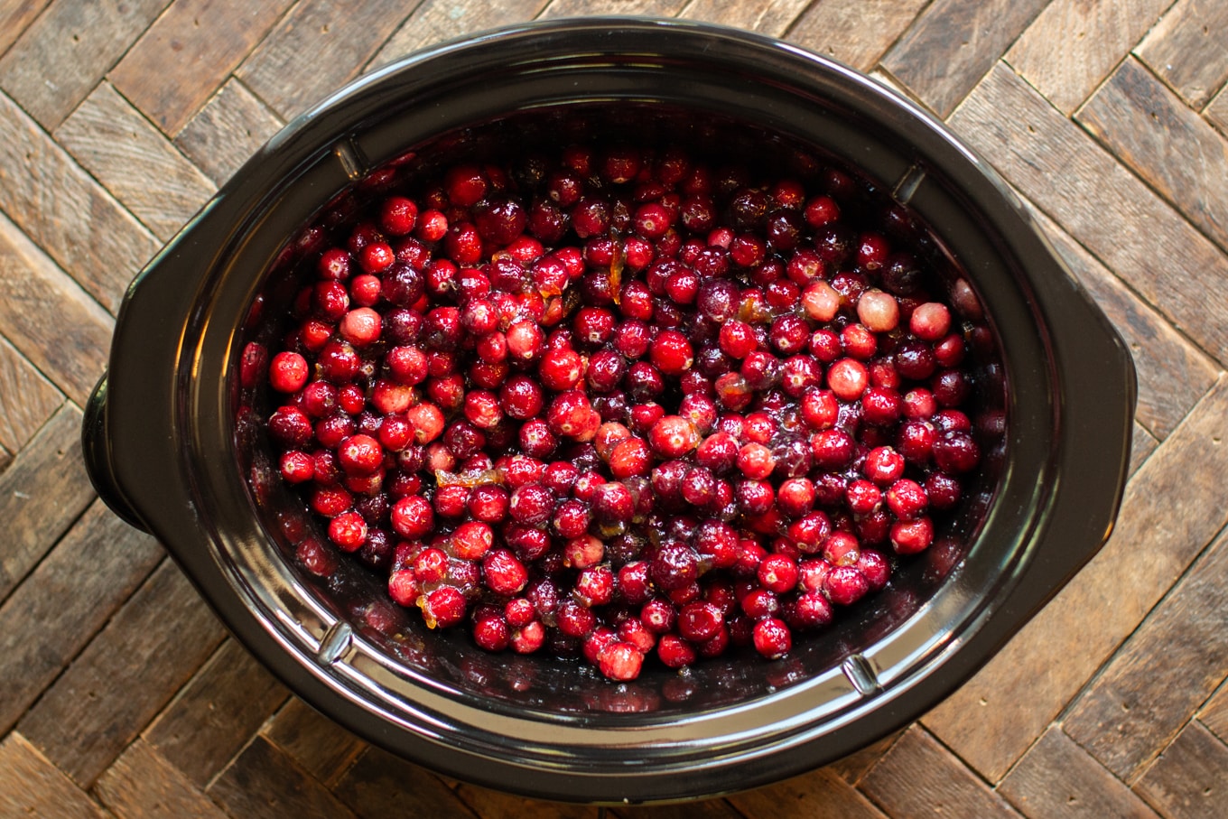 raw cranberries and orange marmalade in a slow cooker.