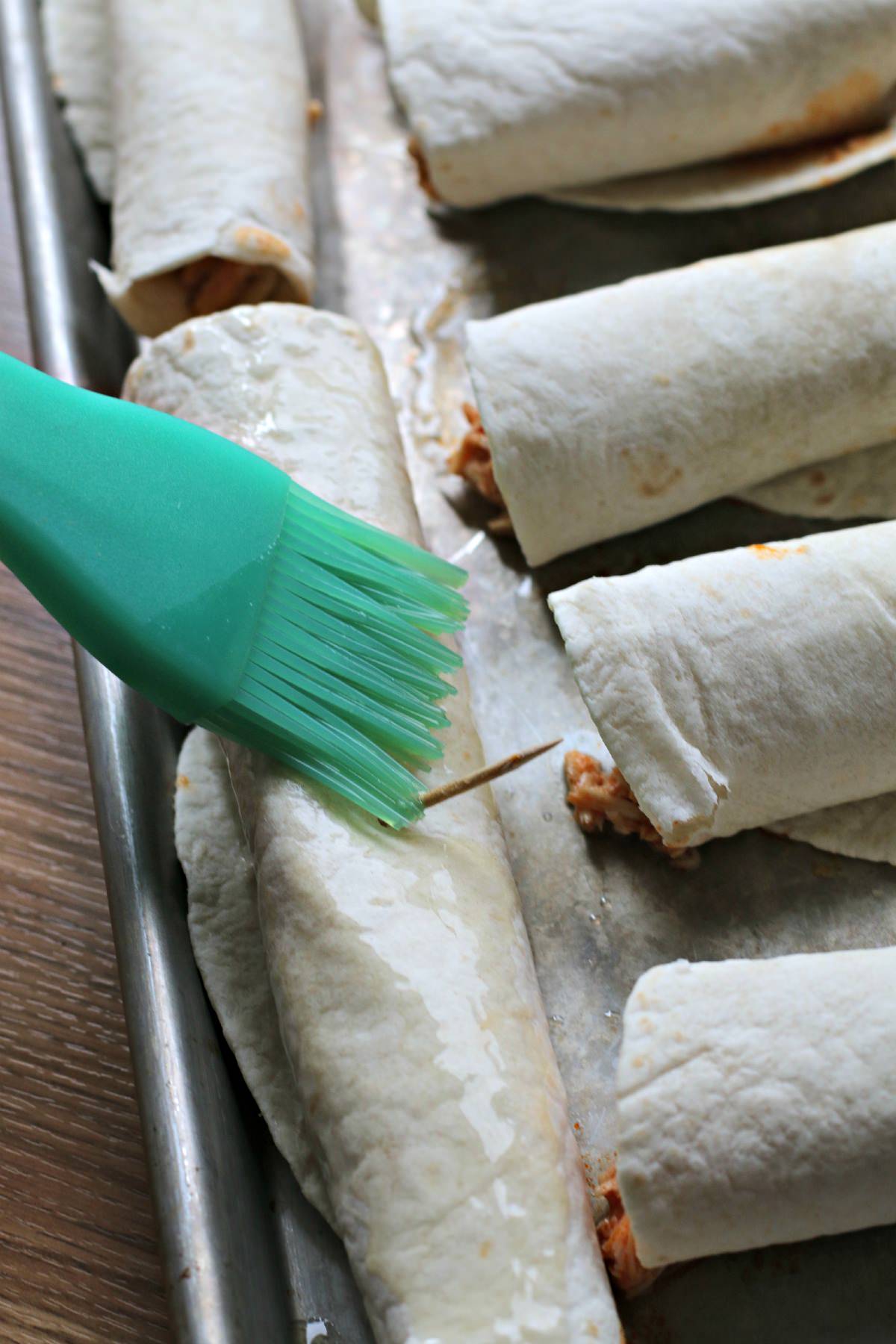 brushing butter on flautas