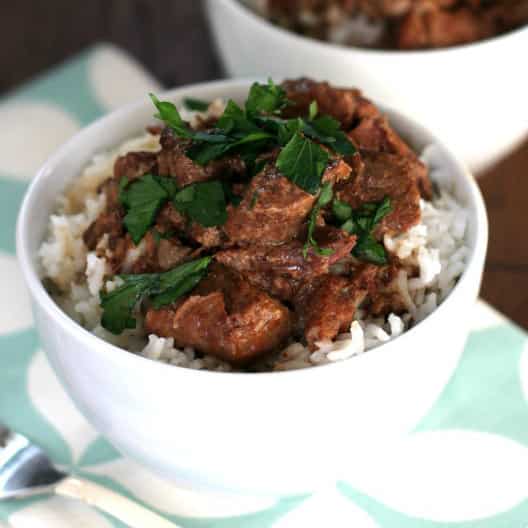 beef tips and gravy over rice in small white bowl