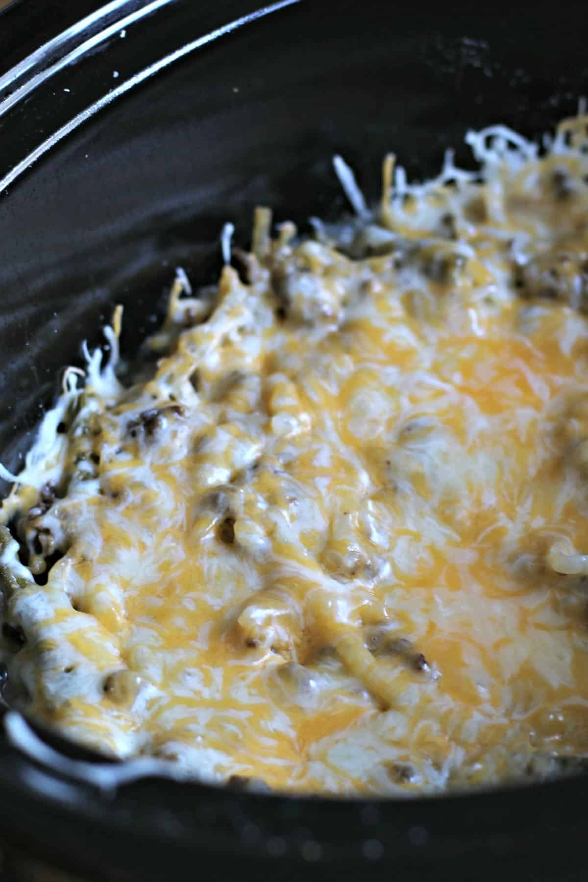 close up photo of lightened up tater casserole in slow cooker, fully cooked