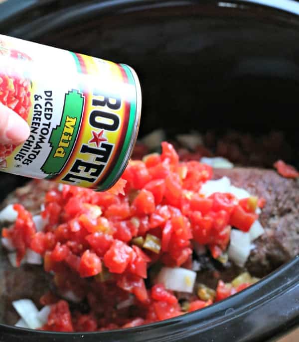 Making beef for sheet tray nachos, pouring Rotel tomatoes over chuck roast