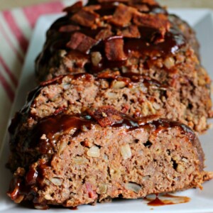 sliced meatloaf with bacon and barbecue sauce on top.
