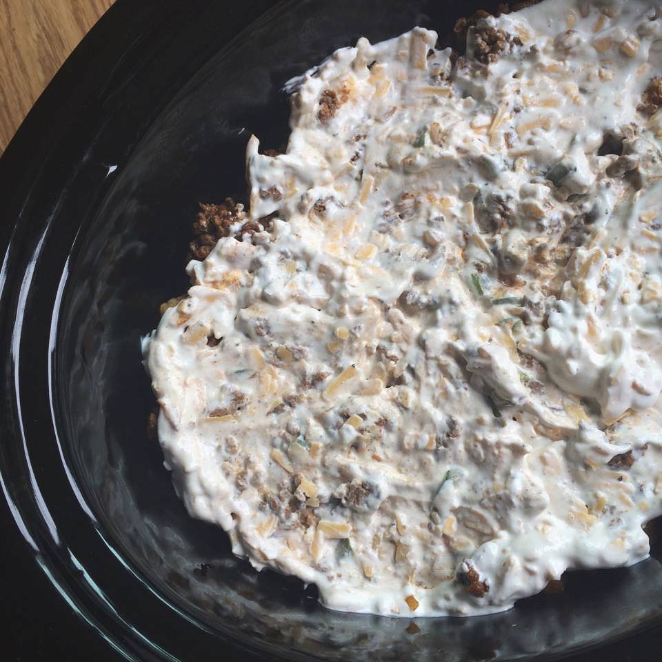 cheese and sour cream over ground beef in the slow cooker.