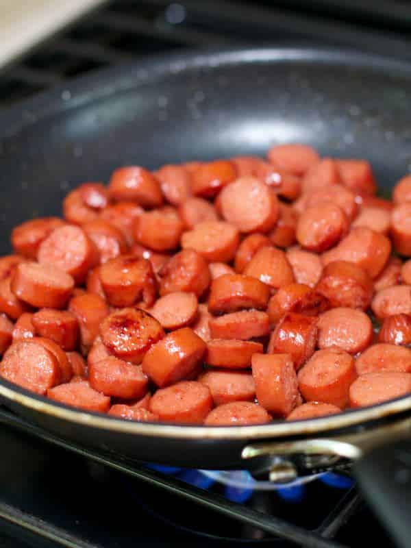 sliced hot dogs in skillet.