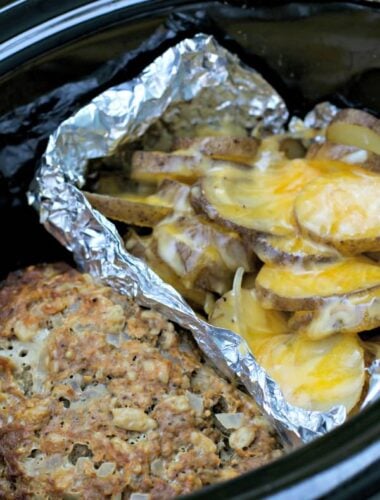 small meatloaf and cheesy potatoes in foil, in slow cooker