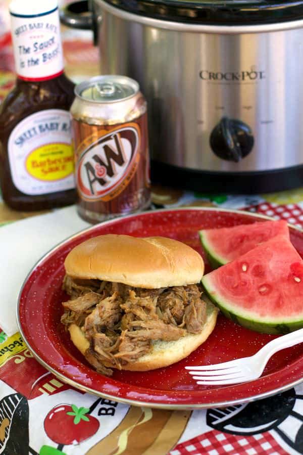 rootbeer pulled pork sandwich on red plate with watermelon on side