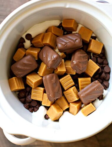 candy bars, caramel and marshmallow fluff in slow cooker