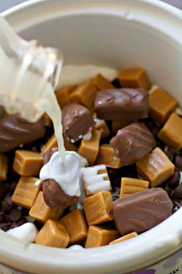 Cream being pour over candies in a slow cooker