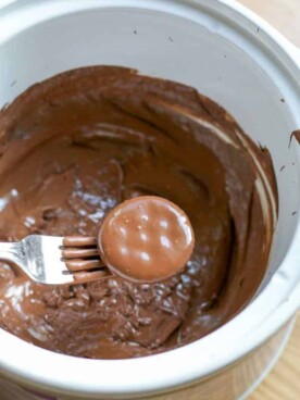 Ritz cracker being dipped into mint chocolate in slow cooker