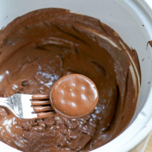 Ritz cracker being dipped into mint chocolate in slow cooker