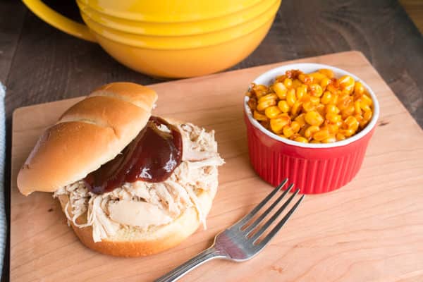 shredded chicken sandwich with corn on the side.