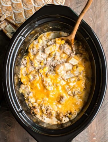 hamburger hash in slow cooker with wooden spoon.