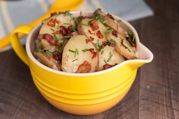 close up of red potato salad in yellow bowl