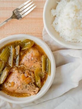 bowl of pepper chicken with rice on side.