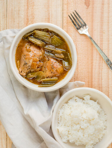 2 white bowls one with black pepper chicken and the other with white rice.