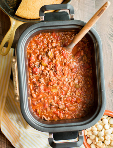 beef chili in slow cooker with cornbread and oyster crackers on the side.