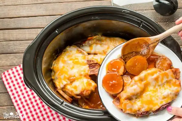 Patatas y chuletas de cerdo en el plato, en la olla de cocción lenta.