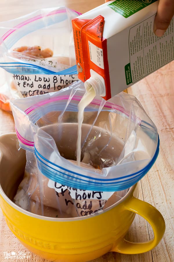 chicken broth being poured into chicken pot pie soup ziplock bag.