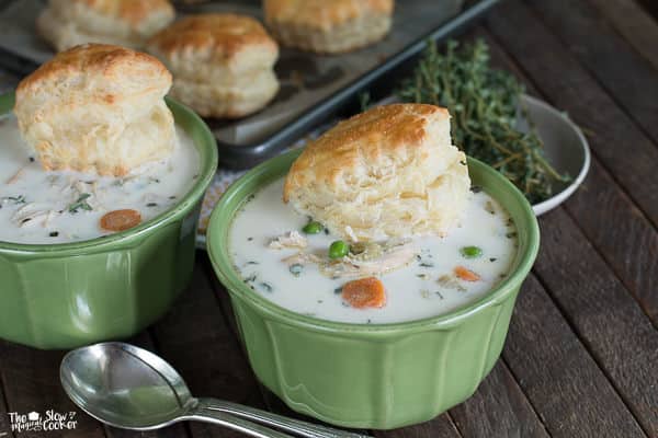 2 green bowls of chicken pot pie soup with puff pastry biscuits on top